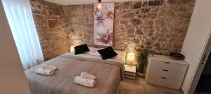 Un dormitorio con una cama y una pared de piedra. en Apartment Kala, en Split