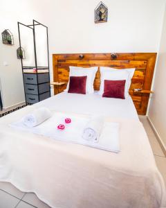 ein Schlafzimmer mit einem großen weißen Bett mit Handtüchern darauf in der Unterkunft Studio Jacuzzis et piscine au centre ville de Port-Louis in Port-Louis