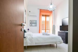 sypialnia z łóżkiem, telewizorem i oknem w obiekcie Aurora Residence w mieście Gela