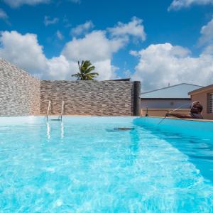 een man in een zwembad bij T3 Jacuzzis et piscine au centre ville de Port-Louis in Port-Louis