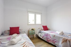 Apartamento Lagloria في غرناطة: غرفة نوم بسريرين عليها مناشف