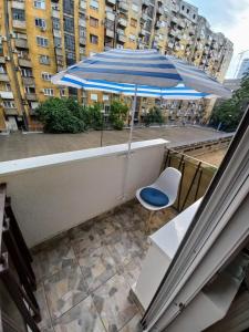 un ombrellone blu e una sedia sul balcone di Apartment Danica a Belgrado