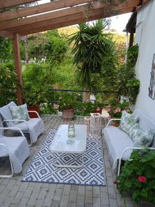 a patio with couches and a table on a rug at Adam's House in Achladies