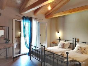 a bedroom with two beds and a large window at Spiro's cottage by Alegria apartments in Vlachopoulátika