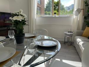 a living room with a glass table and a couch at City Haven King En-suite & Double Room With Parking in London