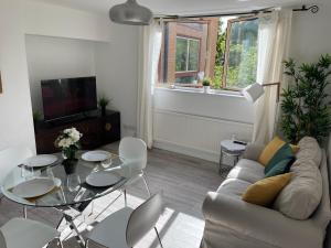 ein Wohnzimmer mit einem Sofa und einem Tisch in der Unterkunft City Haven King En-suite & Double Room With Parking in London