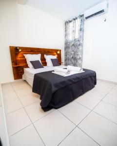 a bedroom with a large bed with a black blanket at T2 Jacuzzis et piscine au centre ville de Port-Louis in Port-Louis