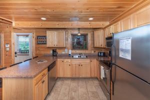 a kitchen with wooden cabinets and a stainless steel refrigerator at Mountain Creek Lodge in Pigeon Forge +42 photos