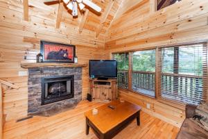 a living room with a fireplace and a tv at Mountain Creek Lodge in Pigeon Forge