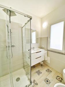 a bathroom with a glass shower and a sink at Cocciu D'Amuri in Olbia
