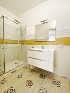 a bathroom with a sink and a glass shower at Cocciu D'Amuri in Olbia