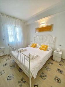 a white bed with two orange pillows in a bedroom at Cocciu D'Amuri in Olbia