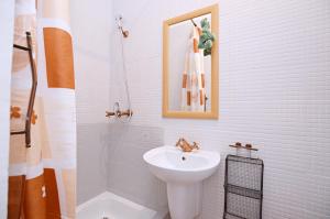 a white bathroom with a sink and a shower at Studio Sopot Sklodowskiej-Curie in Sopot