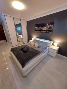 ein Schlafzimmer mit einem großen Bett und einem großen Fenster in der Unterkunft Apartament Wenedów in Koszalin