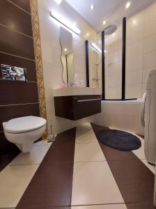 a bathroom with a toilet and a sink and a tub at Apartament Wenedów in Koszalin