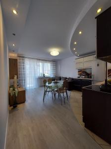 eine Küche und ein Esszimmer mit einem Tisch und Stühlen in der Unterkunft Apartament Wenedów in Koszalin