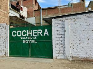 una puerta de garaje verde con un cartel de hotel en Hotel Villa del Sol en Piura