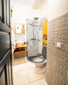 a bathroom with a toilet and a shower at Studio jacuzzis et piscine au centre ville de Port-Louis in Port-Louis