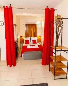 1 dormitorio con cortinas rojas y 1 cama en Studio jacuzzis et piscine au centre ville de Port-Louis, en Port-Louis