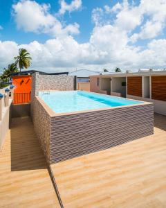 einem Pool an der Seite eines Gebäudes in der Unterkunft Studio jacuzzis et piscine au centre ville de Port-Louis in Port-Louis