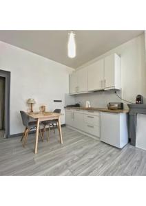 アヌシーにあるCoup de Coeur au pied du château - Nice studio ideally locatedの白いキャビネット、テーブルと椅子付きのキッチンが備わります。