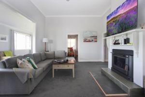 a living room with a couch and a fireplace at Black Possum Cottage Views of the Bay in Pindimar