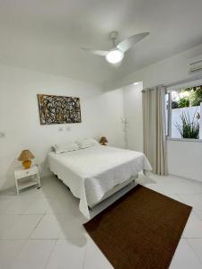 um quarto branco com uma cama e uma janela em Apartment Ilha da Gigóia no Rio de Janeiro