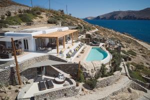 a house on a hill with a swimming pool at Villa Barbarossa - Amazing Beachfront Villa with Heated Pool in Ftelia
