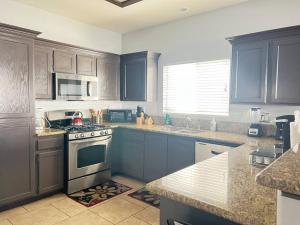 a kitchen with blue cabinets and a stove top oven at Oasis pool house, optional pool heater in Las Vegas