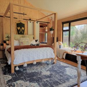 a bedroom with a bed and a large window at Ripples Retreat - Riverside in Piopio