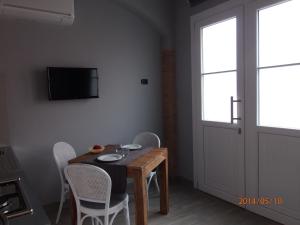une salle à manger avec une table, des chaises et une télévision dans l'établissement Casa Vacanze SanGiacomo, à Santo Stefano al Mare