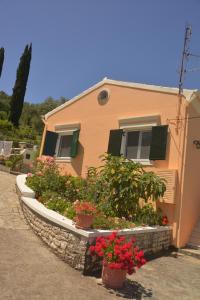 una casa con macetas de flores delante de ella en Georgia Apartments & Studios Corfu en Glyfada