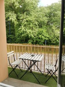 una mesa de picnic y dos sillas frente a una valla en Le Balcon, 500 m plage, proximité Touquet, en Camiers