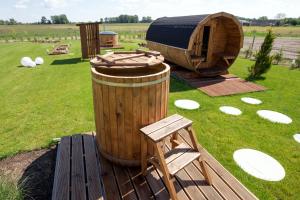 a wooden barrel and a yurt in a field at TeoDorka Med & SPA in Ciechocinek