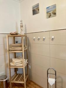 ein Badezimmer mit einem Regal mit Handtüchern darauf in der Unterkunft Ferienhaus Spatzenvilla in Lübeck