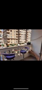 un ensemble de tables et de chaises bleues sur un balcon dans l'établissement nice holiday in Maadi, au Caire