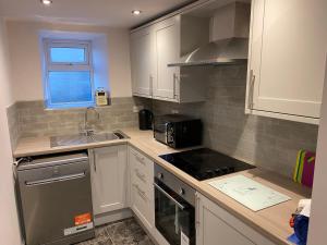 a kitchen with a sink and a stove top oven at Olde Post House, Rathmell - Settle in Settle