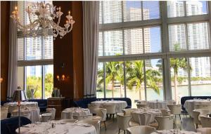 a dining room with white tables and chairs and windows at NEW!!! W Brickell Miami- ICON DELUXE LOUNGE with 2 masters in Miami