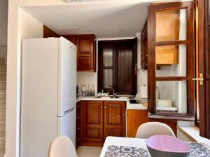 a kitchen with a white refrigerator and wooden cabinets at Canevaro Twins (South) in Chania