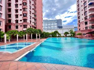 a swimming pool in the middle of two tall buildings at 4 Bedrooms PENTHOUSE MARINA COURT VACATION HOME KOTA KINABALU 14pax in Kota Kinabalu