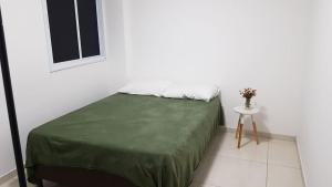 a white room with a bed and a small table at Jockey Family Chamonix 3 in Vila Velha