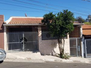 uma casa com um portão e uma árvore em frente em Casa 1km Anhanguera e Churrasqueira Wi-Fi em Louveira