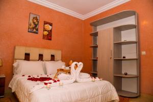 un dormitorio con una cama con una decoración de cisne en Hôtel La Citta Rossa, en Marrakech