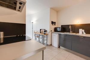 - une cuisine avec un évier et un comptoir dans l'établissement Le Basilique - Joli T2 de 59m proche lac et Vieille Ville, à Annecy