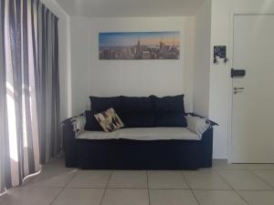 un sofá en una habitación con una foto en la pared en Apartamento próximo ao shopping, en Poços de Caldas
