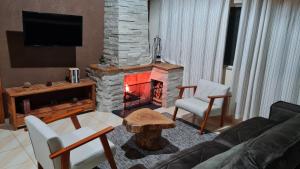 sala de estar con chimenea y sofá en Recanto do Lago no Santa Bárbara Resort Residence, en Águas de Santa Bárbara