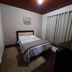 1 dormitorio con 1 cama en una habitación en Casa Avelar Campos do Jordão, en Campos do Jordão