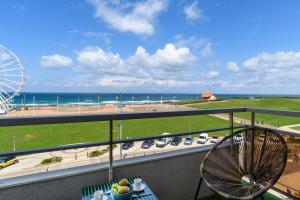 a balcony with a view of the beach and a ferris wheel at La Suite de l'Océan - Vue exceptionnelle in Biscarrosse