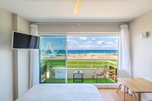 a bedroom with a view of the beach from a window at La Suite de l'Océan - Vue exceptionnelle in Biscarrosse