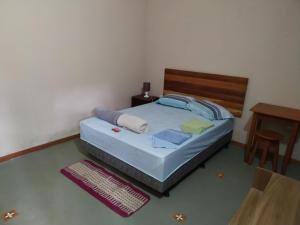 a bedroom with a bed with a wooden head board at Pousada do guariba in Santa Teresa